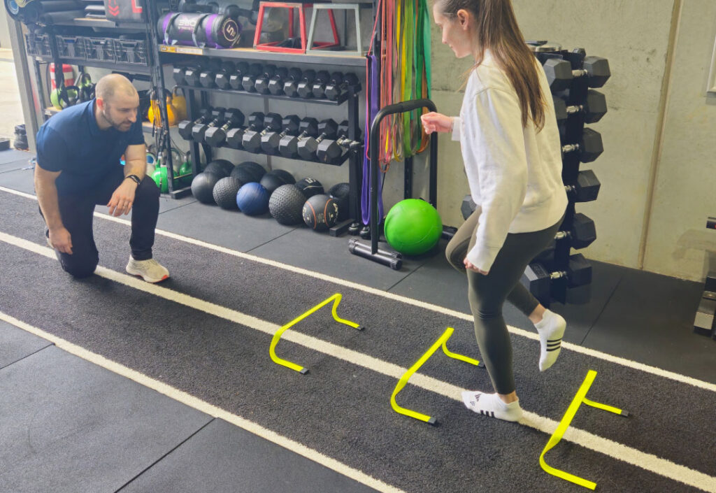 A client performing ankle rehabilitation exercises in the gym under physio guidance.