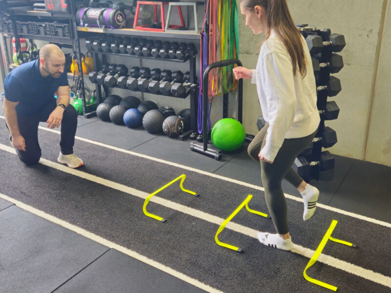 A client performing ankle rehabilitation exercises in the gym under physio guidance.