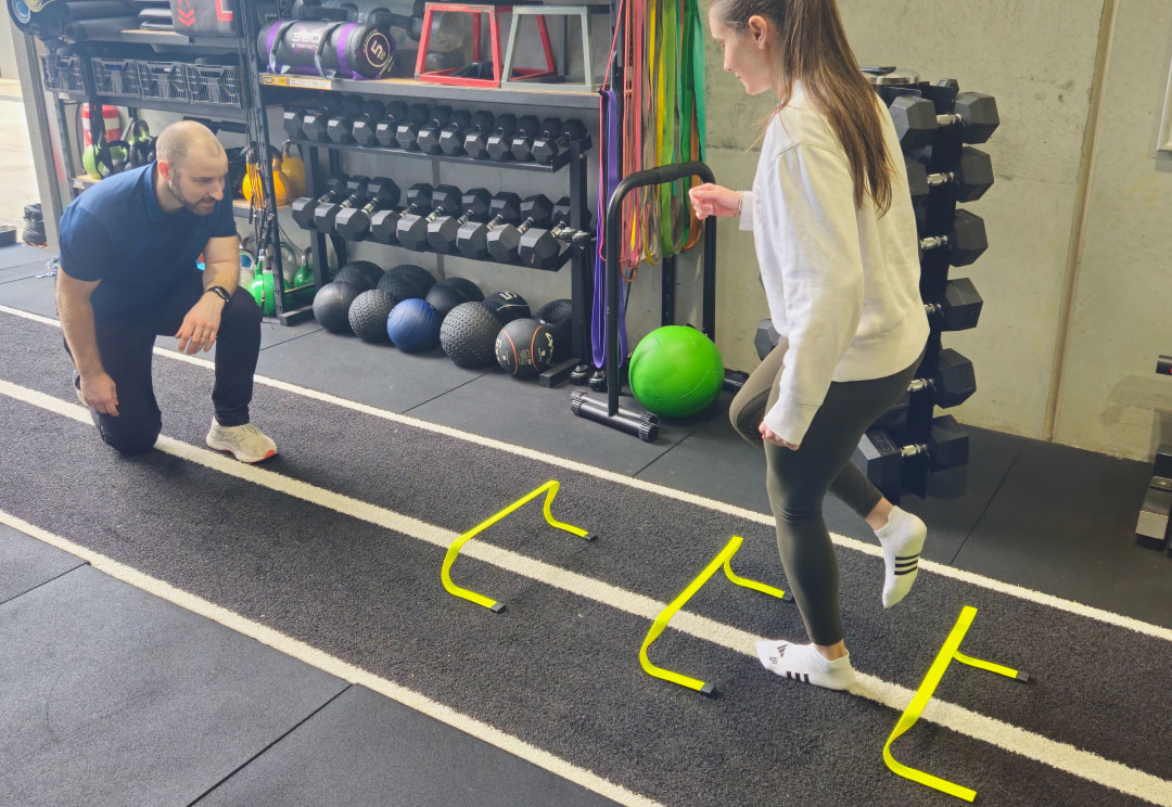 A client performing ankle rehabilitation exercises in the gym under physio guidance.
