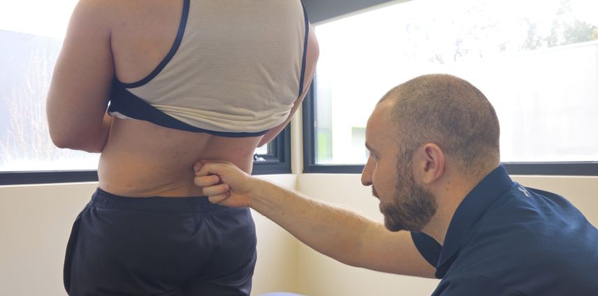 Physiotherapist assessing lower back pain in a Mooroolbark patient at Adapt Sports Physiotherapy Chirnside Park