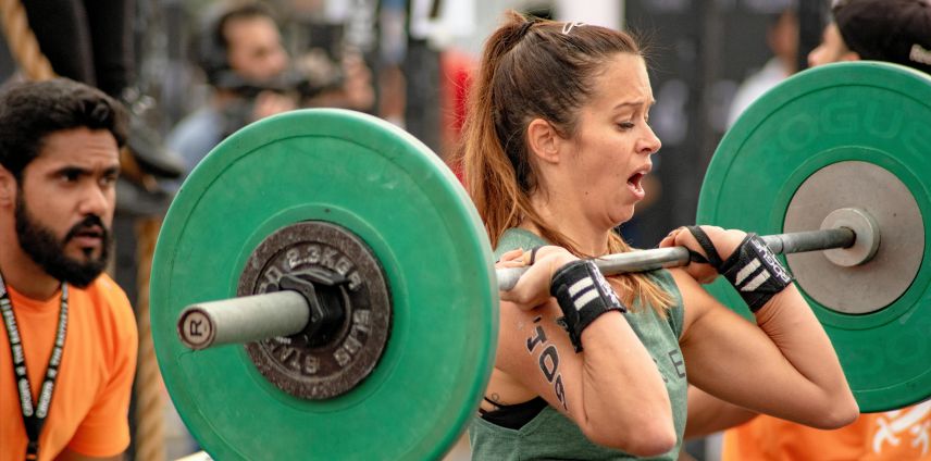 Athlete competing in a weightlifting event, lifting a barbell overhead