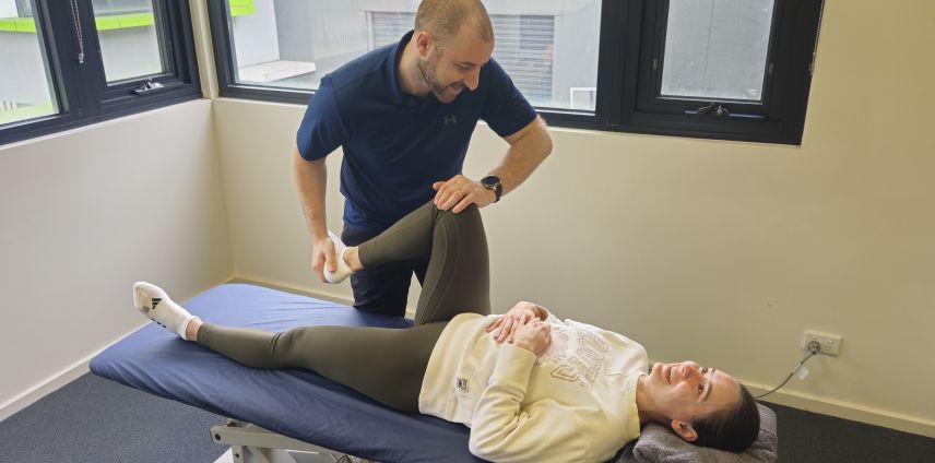 Physiotherapist examining a patient's knee on the treatment table