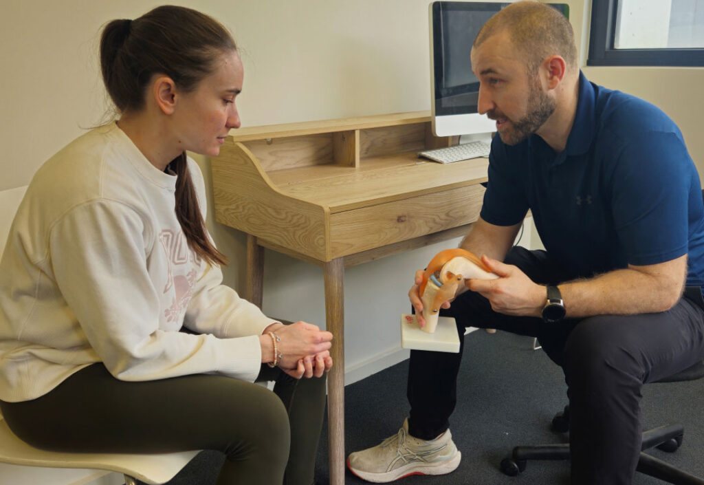 A physiotherapist explaining muscular anatomy to a client.