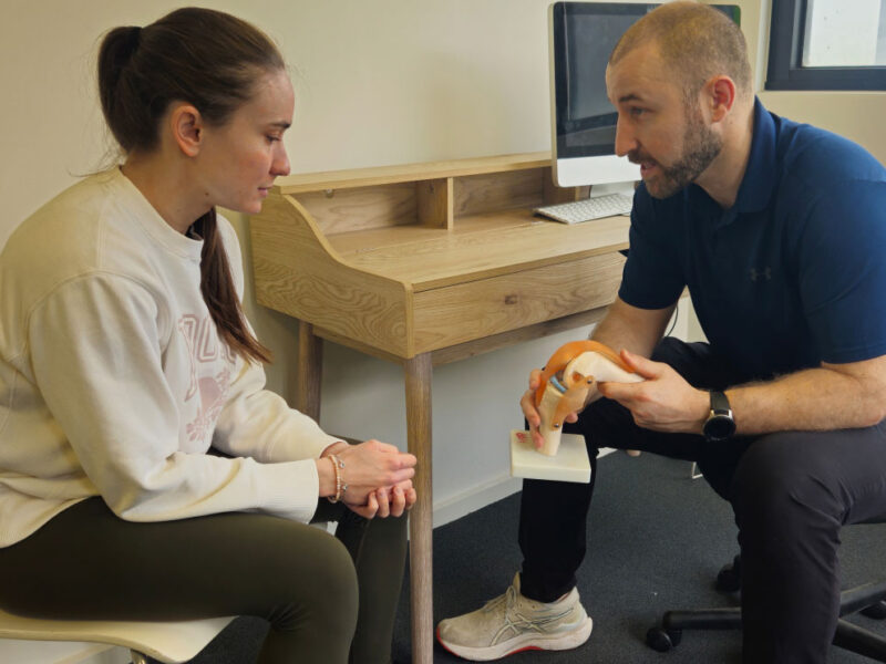A physiotherapist explaining muscular anatomy to a client.