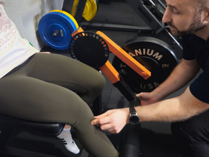A physiotherapist inspecting a client's knee in the rehabilitation gym.