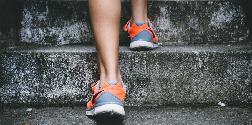Close-up of a runner's legs and shoes ascending outdoor stone steps