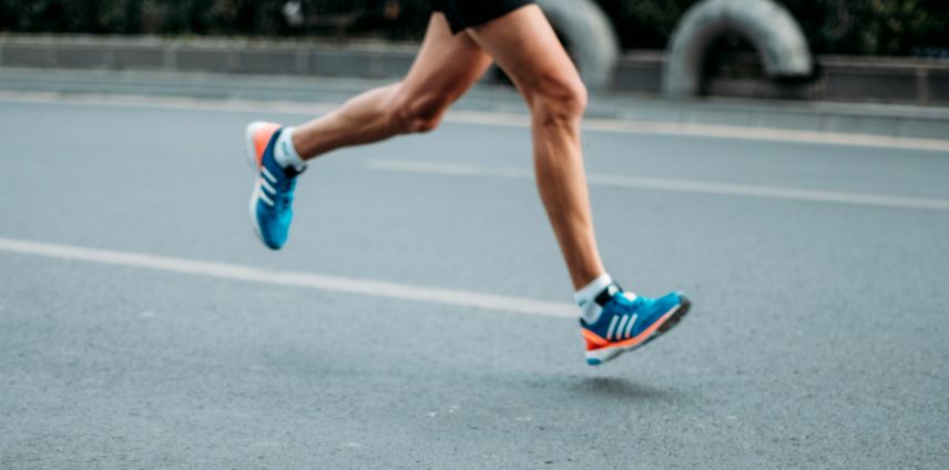 Close-up of a runner's legs mid-stride on a road