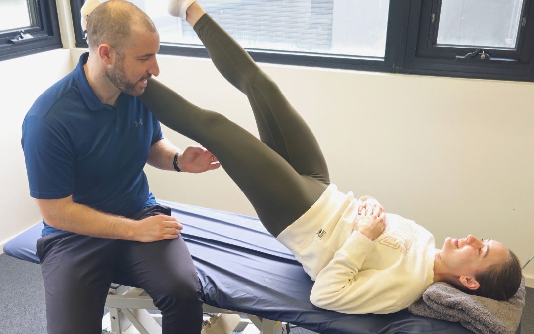 Physiotherapist assessing a runner's leg during a sports physiotherapy consultation