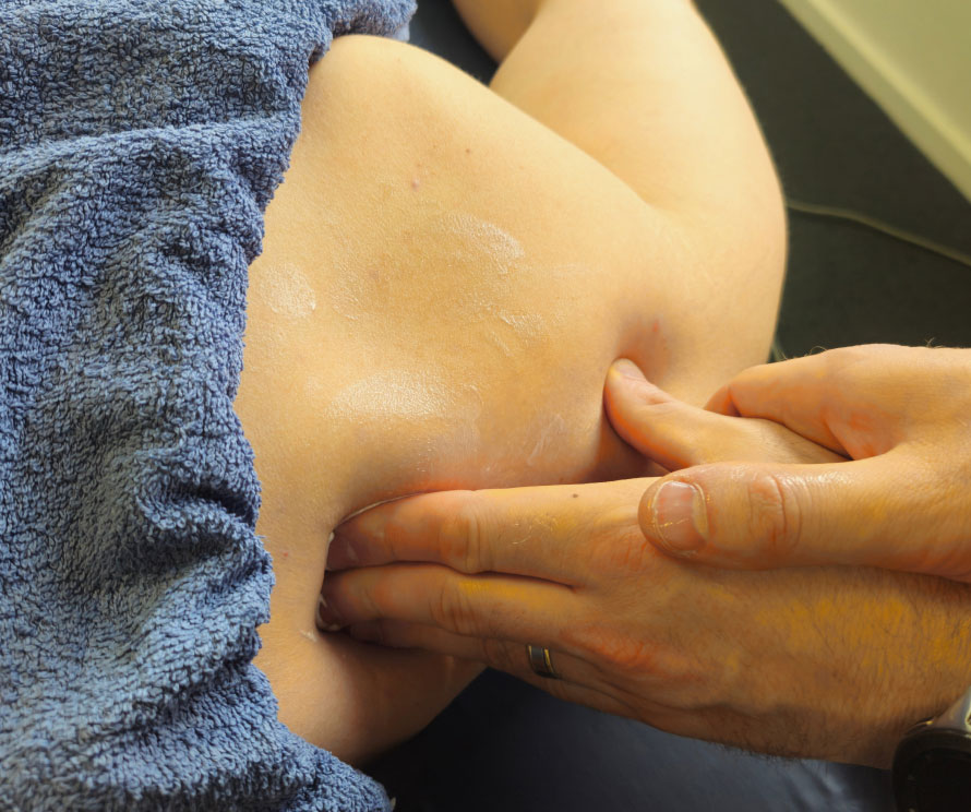 A physiotherapist performing a shoulder massage as part of treatment.