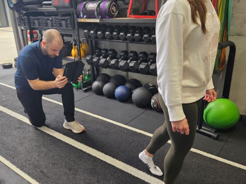 A sports physiotherapist analysing a client's injury during assessment.